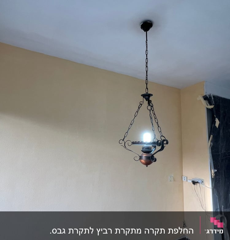 קיר גבס עם שקעי חשמל וגוף תאורה תלוי